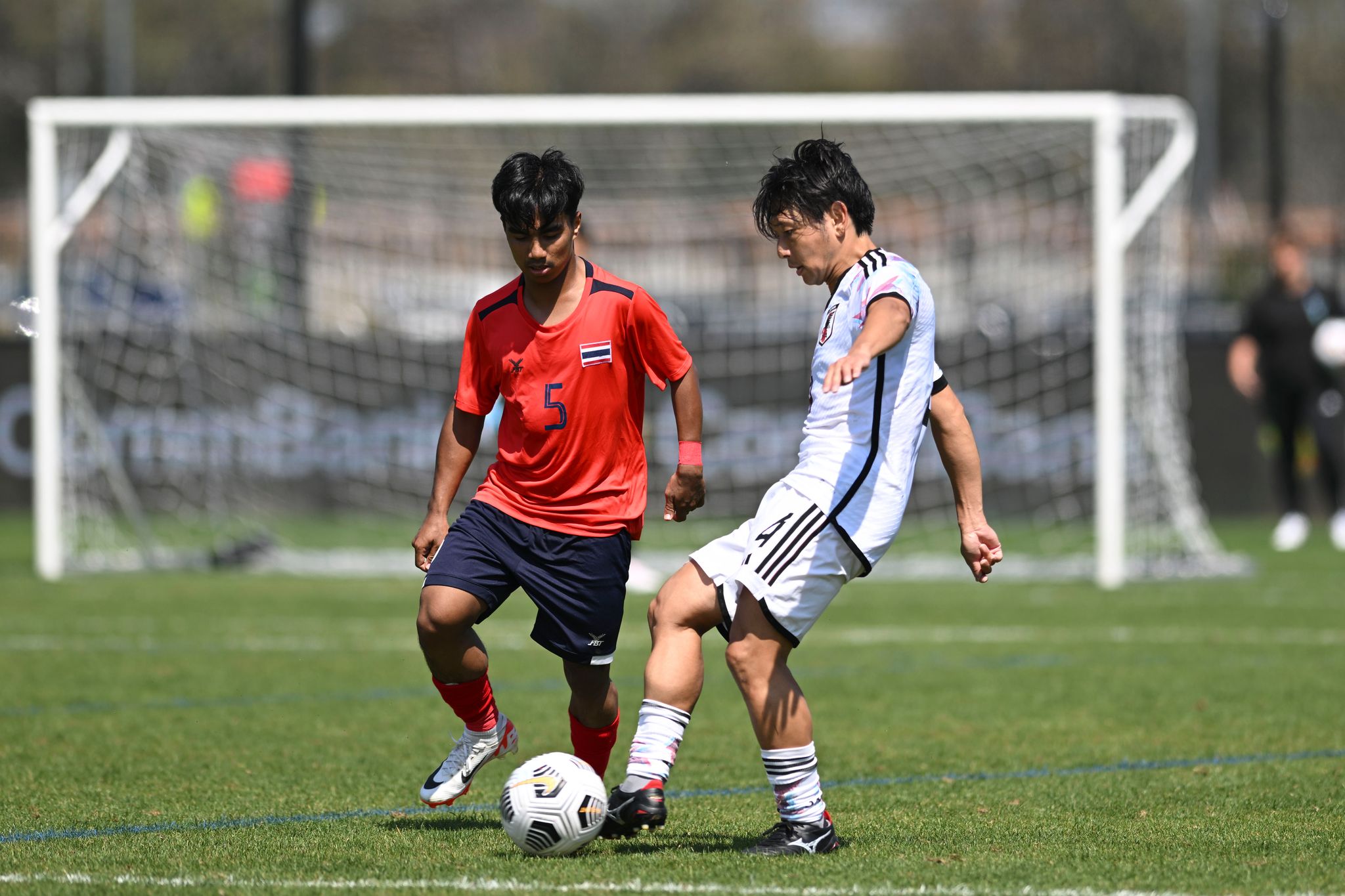 Attan Tahe of Thailand and Hiroki Kameno of Japan compete for the ball